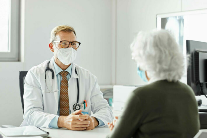primary care physician discussing healthcare with elderly patient